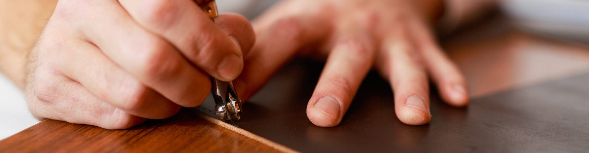 Master of leathercraft carrying out one of stages of wallet production